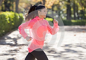 Attractive and happy runner woman in Autumn sportswear running a