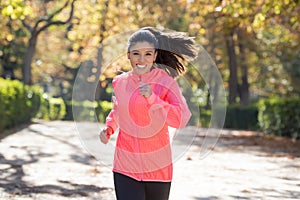 Attractive and happy runner woman in Autumn sportswear running a