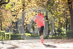 Attractive and happy runner woman in Autumn sportswear running a