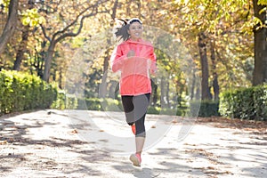 Attractive and happy runner woman in Autumn sportswear running a