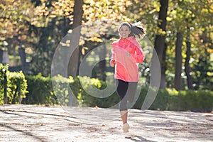 Attractive and happy runner woman in Autumn sportswear running a