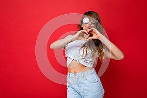 Attractive happy young blonde woman wearing everyday stylish clothes and modern sunglasses isolated on colorful