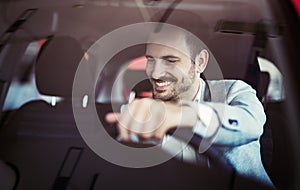 Attractive happy young man driving car and smiling