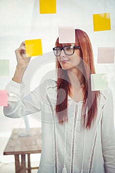 Attractive hipster woman writing on sticky notes