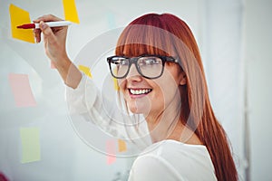 Attractive hipster woman writing on sticky notes