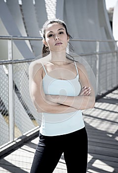 Attractive hispanic brunette woman looking cool and defiant after running workout