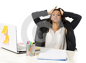 Attractive hispanic businesswoman or secretary suffering breakdown and headache in stress at office
