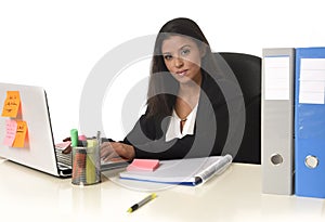 Attractive hispanic businesswoman sitting at office desk working on computer laptop smiling happy