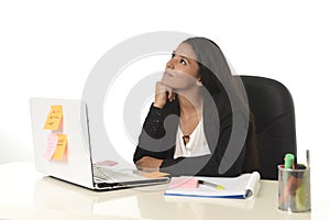 Attractive hispanic businesswoman sitting at office desk working on computer laptop smiling happy