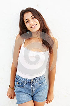 Attractive Hispanic Teenage Girl Leaning Against Wall