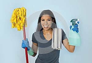 Attractive hispanic woman happy proud as home or hotel maid cleaning and housekeeping holding soap spray and mop