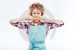 Attractive housewife holding and biting uncooked spagetti