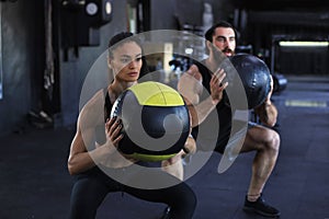 Attractive indian couple doing fitness with medcine ball at gym