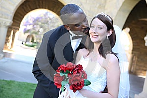 Attractive Interracial Wedding Couple Kissing photo