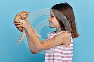 Attractive kind girl lifting her cat, loves it, adores pet photo