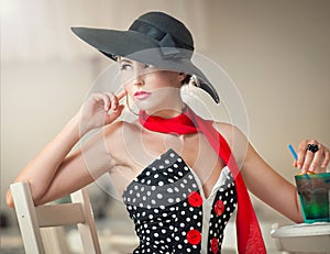 Attractive lady with black hat and red scarf sitting in restaurant