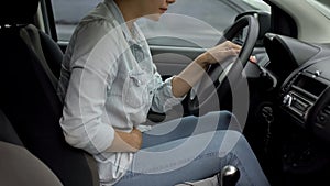 Attractive lady driving car feeling strong premenstrual pain, hormone imbalance photo