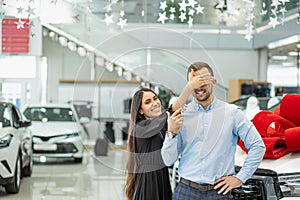 Attractive lady going to give new car as a gift to man