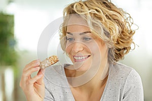 Attractive lady holding cereal bar