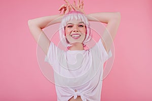 Attractive lady with little tattooes posing on pastel background with smile. Indoor shot of carefre