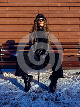 Attractive lady sits on the bench outdoors