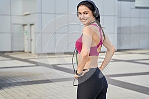 Attractive lady in sportswear using wireless headphones