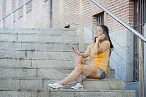 Attractive latin woman listening to music on her smart phone