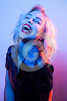 Attractive laughing woman dressed in fashion apparel in neon night lights.