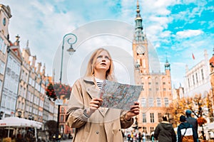 Lost young woman traveling with map in the central square in Gdansk old town. Traveling in Poland