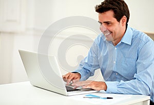 Attractive male entrepreneur working on his laptop