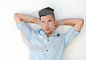 Attractive male fashion model with hands behind head