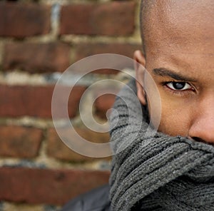 Attractive male fashion model with scarf covering face