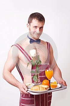 Attractive man in an apron with breakfast