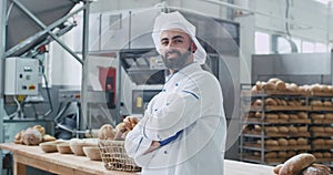 Attractive man baker in a stylish uniform smiling large in front of the camera he enjoying the time at his work place in