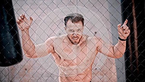 An attractive man bodybuilder standing behind the net