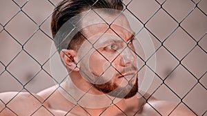 An attractive man bodybuilder standing behind the net