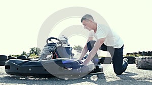 Attractive man checking tire pressure on his gocart