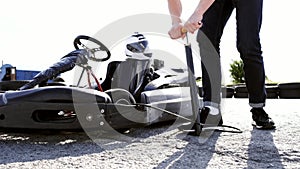 Attractive man checking tire pressure on his gocart