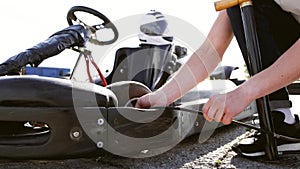 Attractive man checking tire pressure on his gocart