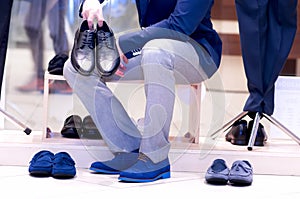 Attractive man chooses a shoes.