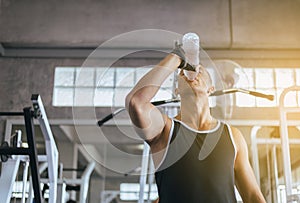 Attractive man drinking water in gym,Men break and relex after workout