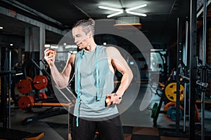 young handsome athlete hungry and eating healthy apple fruit in gym