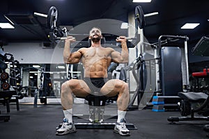 Attractive man exercising with training apparatus in gym.