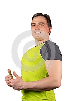 Attractive man in green t-shirt shows thumbs up isolated on white background