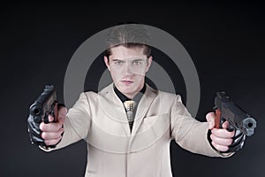 Attractive man with a gun wearing a white suit