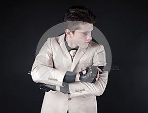 Attractive man with a gun wearing a white suit
