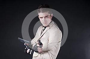 Attractive man with a gun wearing a white suit