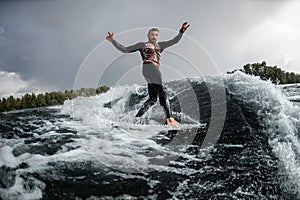 Atractivo hombre divirtiéndose conduciendo ola sobre el surfear en verano 