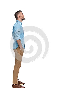 Attractive man in his forties standing in line with hands in pockets