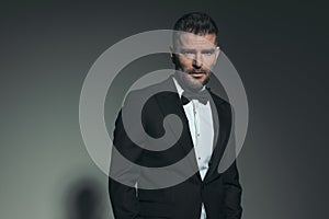 Attractive man in his forties wearing black tuxedo and posing